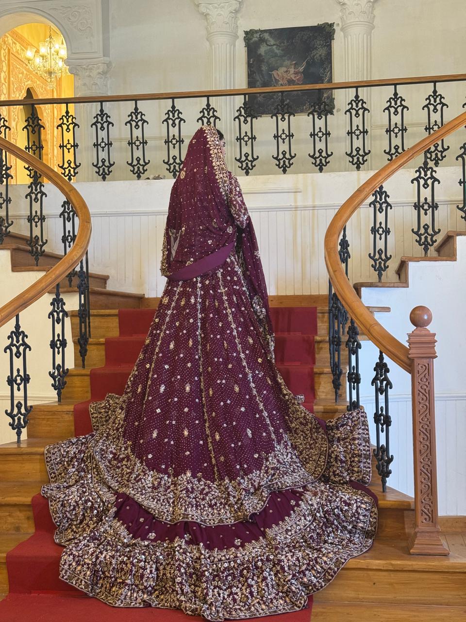 Back view of the KANZARA Shehnaz plum bridal lehenga showing the full tiered train